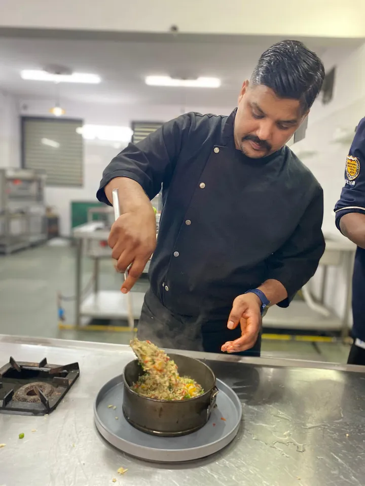 "Students receiving chef training in a modern kitchen at the Culinary College of Hotel Management in Dehradun."